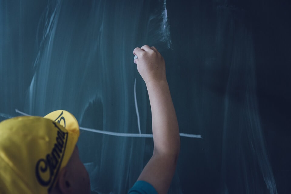 Boy writing on blackboard